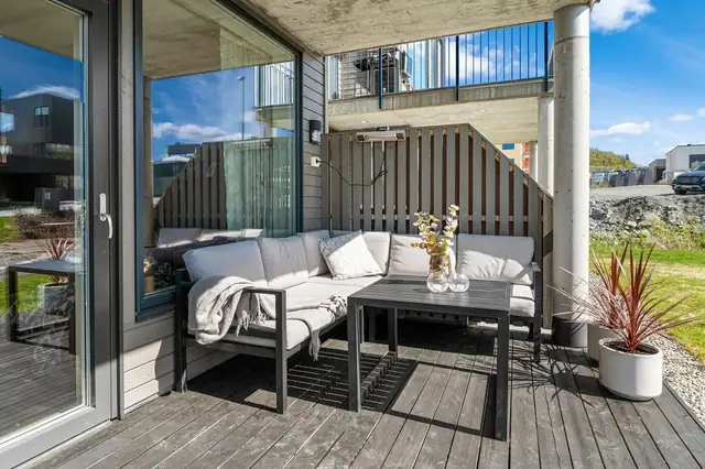 Koselig terrasse vendt ut mot pent opparbeidet, trivelig og svært barnevennlig fellesareal.