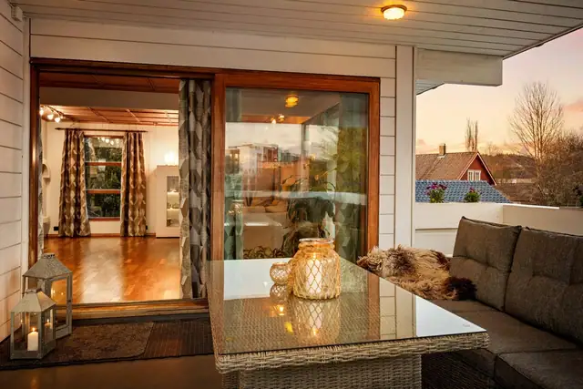 Med store glassflater og skyvedør blir verandaen en naturlig forlengelse av stuen.