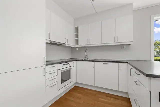 Stort kjøkken med rikelig med skap- og benkeplass.