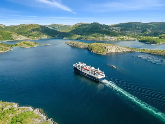 Fra tomtene kan man se Hurtigruten passere.