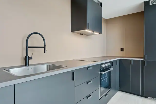 Pent og moderne kjøkken med integrerte hvitevarer.