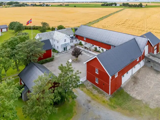 På tunet står en enebolig, garasje, fjøs med låve og stabbur.