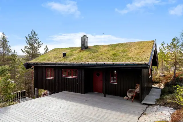 Stor terrasse binder sammen hytte og anneks.