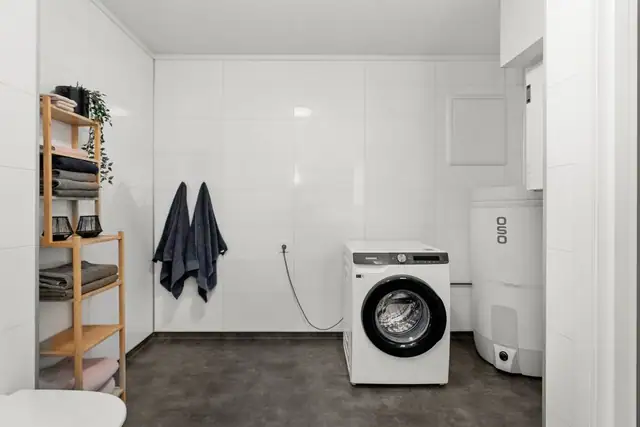 Stort og romslig bad med plass til vaskemaskin uten at det føles trangt.