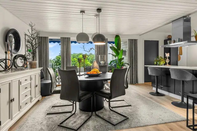 Spisestuen og kjøkken er kledd i stilige og moderne farger.