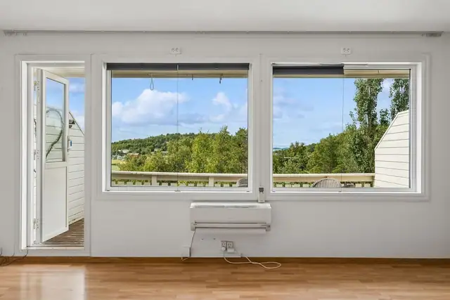 Store vindusflater slipper inn rikelig med naturlig lys for luftig atmosfære og rammer inn den fine utsikten.