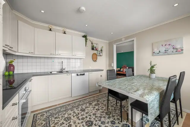 Lyst kjøkken med profilerte fronter og downlights i tak.