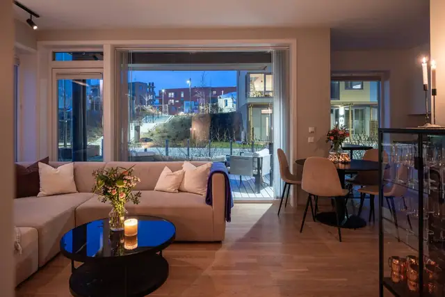 Selv om leiligheten oppleves lys og åpen, har den også en lun og stemningsfull atmosfære.