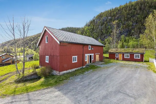 Det sjarmerende og innholdsrike gårdstunet omfatter en stor fjøsbygning og flere uthus som gir gode anvendelsesmuligheter.