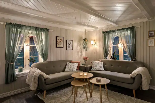 Stua byr på en varm og hjemmekoselig følelse, med vinduer mot det åpne landskapet.