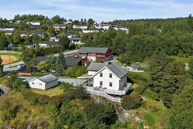 Velholdt enebolig, dobbelgarasje og stor skjermet tomt på ca. 1,5 mål.