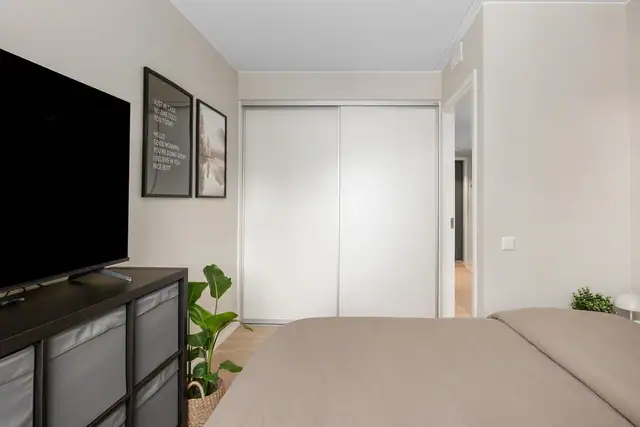 Rommet er utstyrt med praktisk skyvedørsgarderobe med slette fronter.