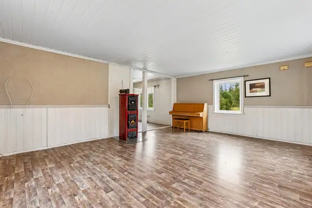 Stua har laminat på gulv, og brystpanel/tapet på vegger.