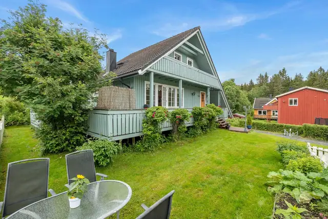 Pent opparbeidet hage med busker og beplantning.