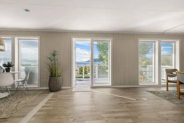 Store vindusflater gir rikelig med naturlig lys og sørger samtidig for at den flotte utsikten kan nytes fra stuen.
