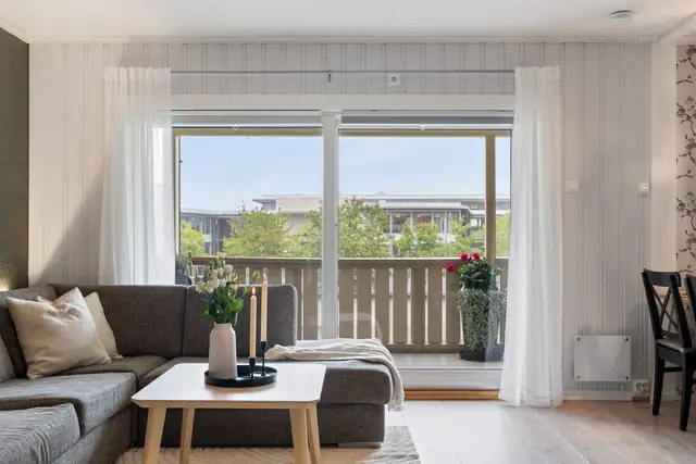 Store skyvedører fra stuen ut til den romslige balkongen, blir som en forlengelse av stuen på fine dager.