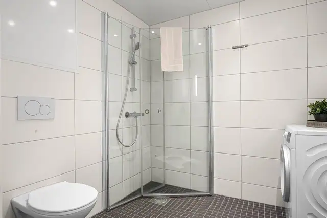 Plassbesparende, innfellbare dusjdører, og god plass til vaskemaskin/trommel.