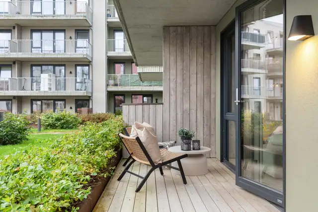 Takoverbygget og adskilt terrasse med beplanting og levegg.