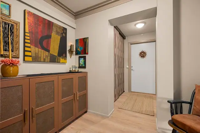 I leilighetens hovedetasje finner vi en innbydende entre med praktisk skyvdørsgarderobe.